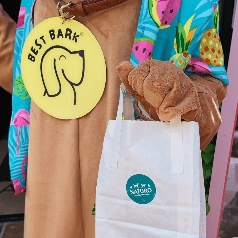 Best Bark mascot holding a Naturo gift bag